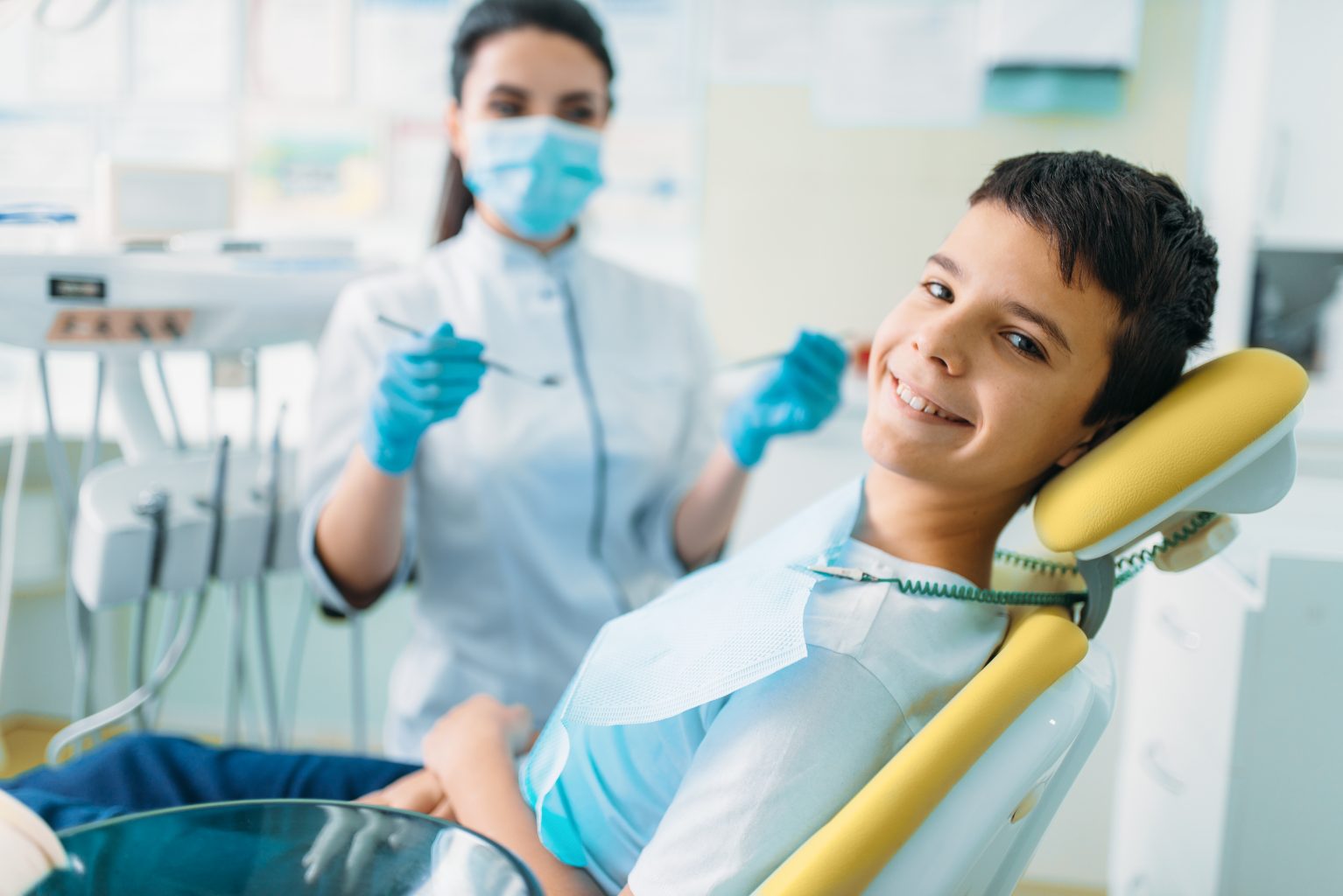 Smiling boy in dentist chair getting checkup.